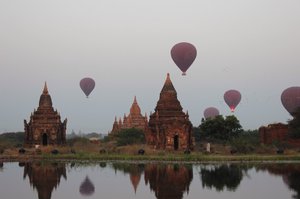 Hot air balloons rising above the pagodas