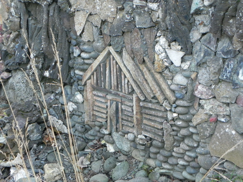 Tiny wooden house in someone&#39;s rock wall. 