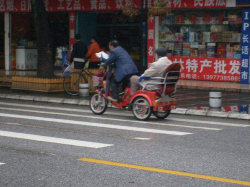 Reading  paper on bike while towing old man