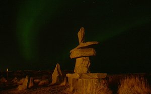 Inuksuk With Aurora Borealis In Background