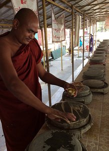 Monk making thanaka frm the wood for face cleaning