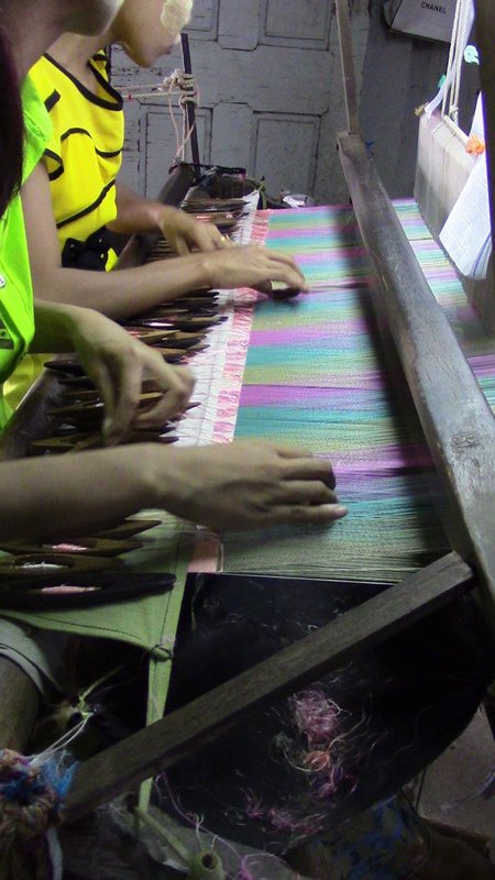 Girls following a chart to weave the design