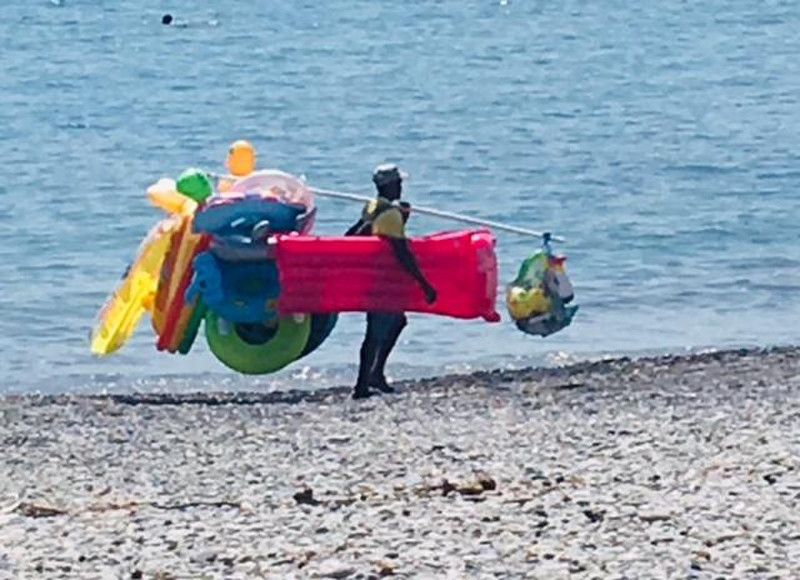 Colorful picture of a man selling his beach items