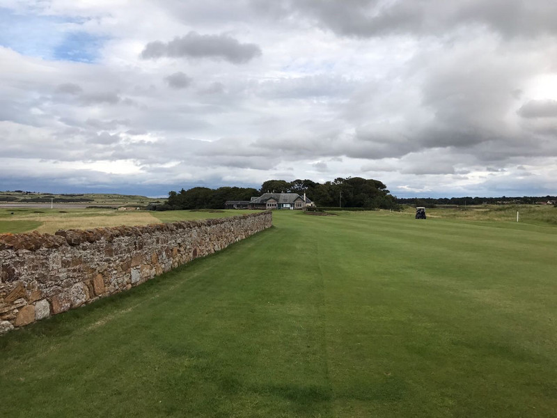 The stone wall flanks the left side of 18