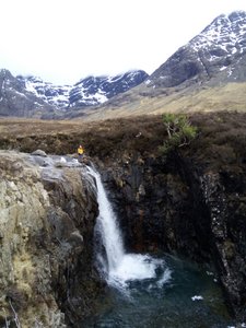 My sister perched atop a waterfall at the Fairy Pools, Skye