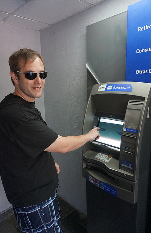 Boomer getting money at a bank ATM
