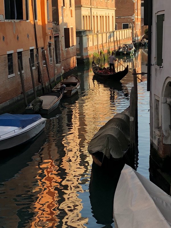 Venice canal with gondolier near sunset