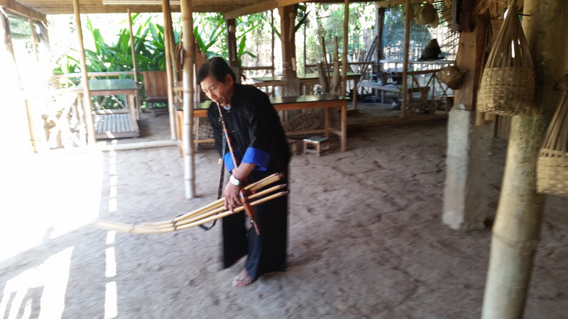 Hmong man playing a traditional instrument 