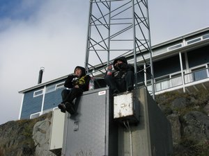 Two little Inuit boys sitting on a power box
