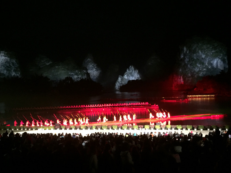 Schlussbild des Freilichtspektakels „Impression Sanjie Liu“ in Jangshuo, hinten einige Berge