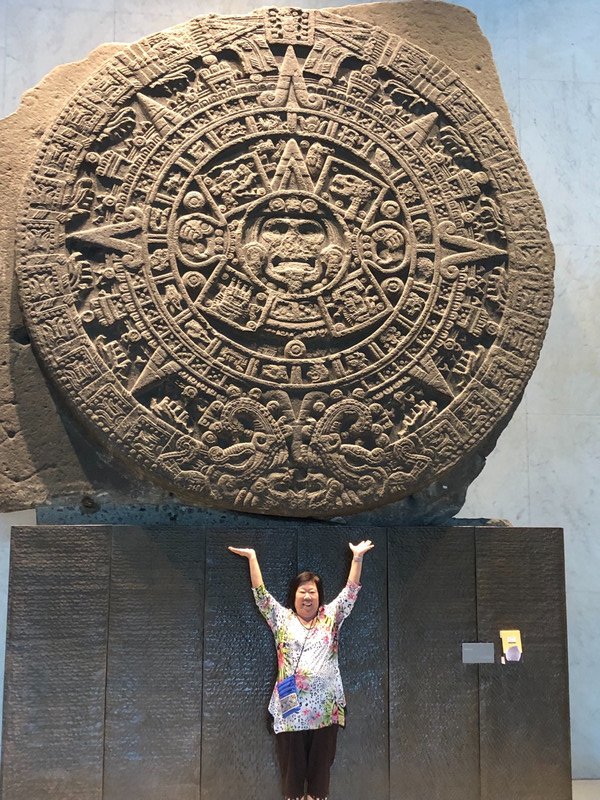 Holding up the Sun Stone, also know as Aztec Calendar 