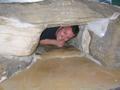 Simon sqeezing through hole in waitomo cave museum