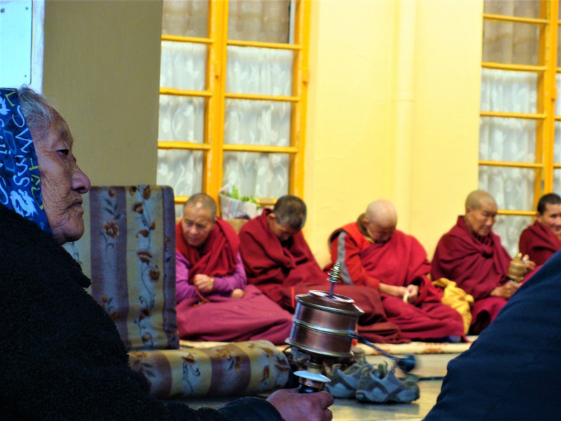 Tibetan monk turning praying wheel