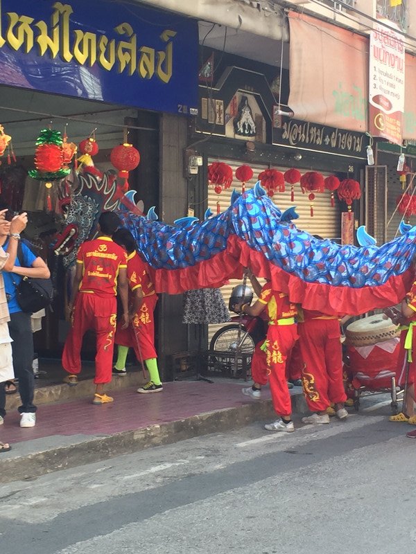 Dragon visiting local shops to collect money and give good luck