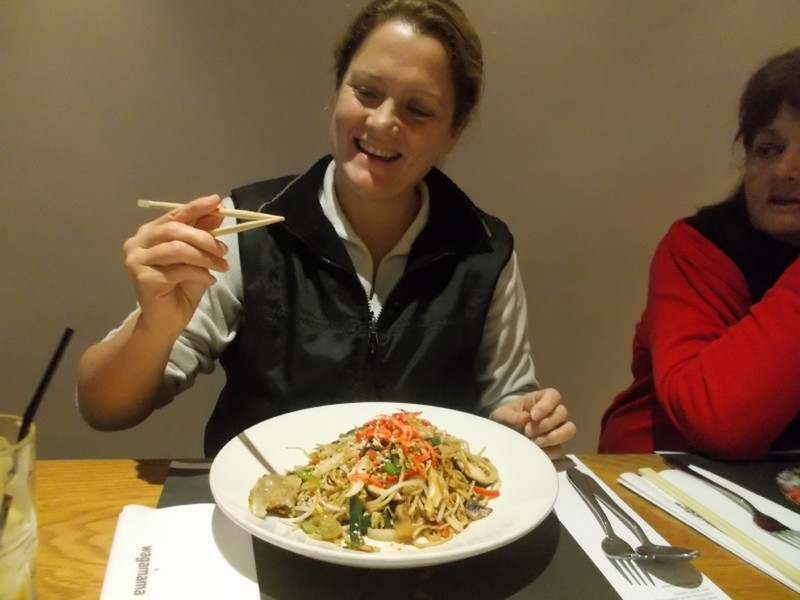 Nikki trying out chopsticks at Wagamama
