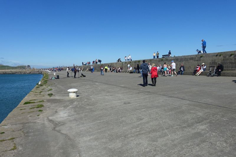 Howth sea wall. Buskers and people enjoying the sunshine.