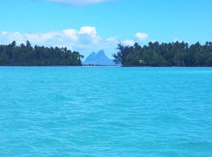 Famous drift snorkeling pass on Tahaa, with Bora Bora in the background