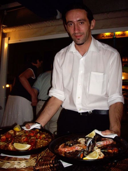 Waiter carrying paella