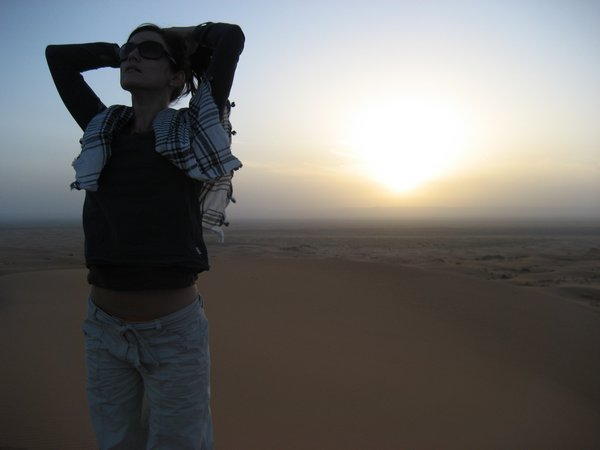 Watching the sun rise over the Sahara from the top of a sand dune, Morocco.