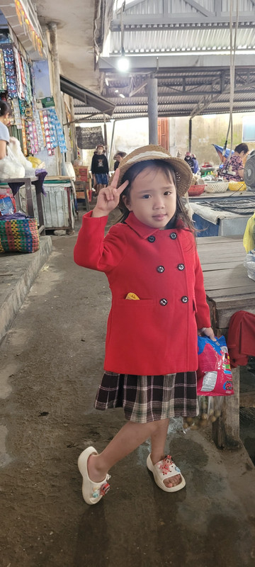 An adorable little girl at the market with her mum. 