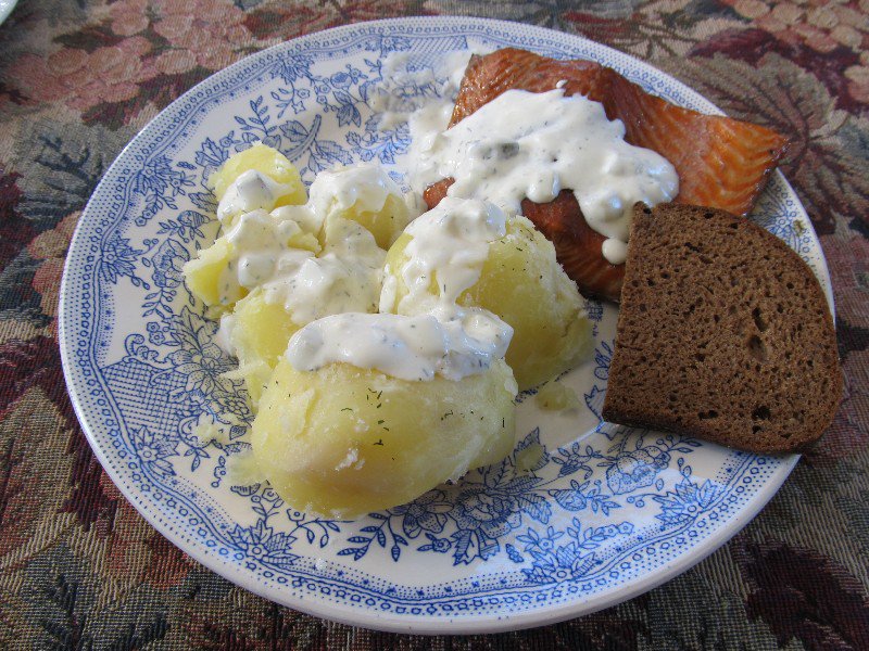 Smoked salmon with typical Estonian black bread, potatoes and sour cream with pickles