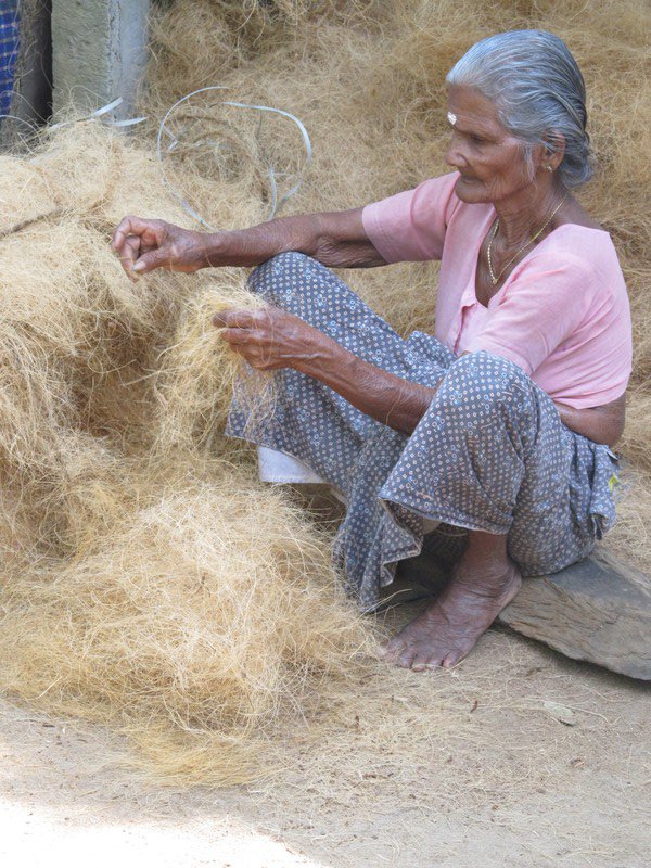 Woman making threads out of coconut fibre in a village in the Kerala Backwaters