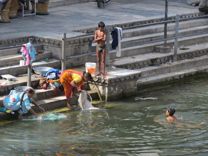 Women washing clothes while the boys are swimming in Lake Pichola, Udaipur