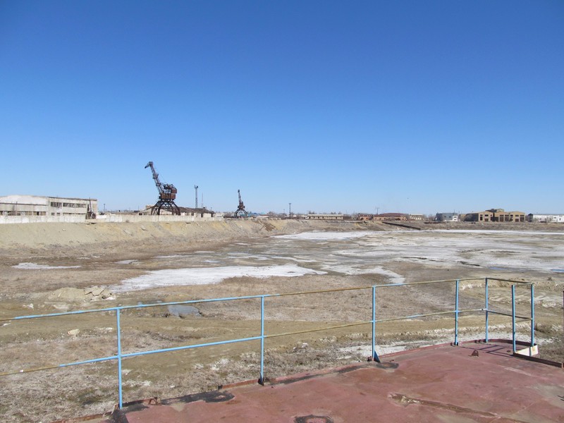 Harbour of Aralsk; abandoned ship, cranes, wharfs and warehouses are witnesses of the glory days of the harbour when there was water