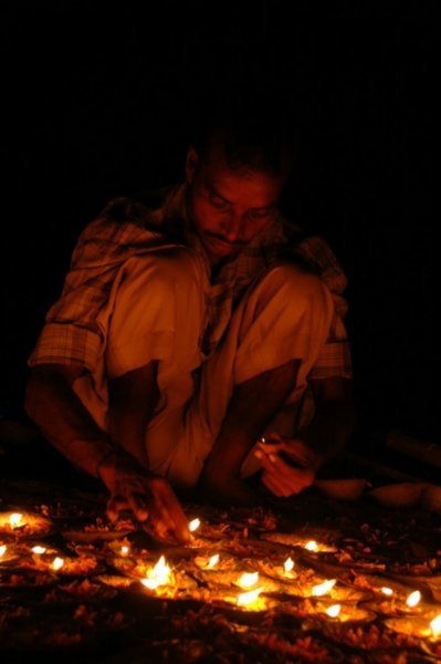Boatman lighting the offerings