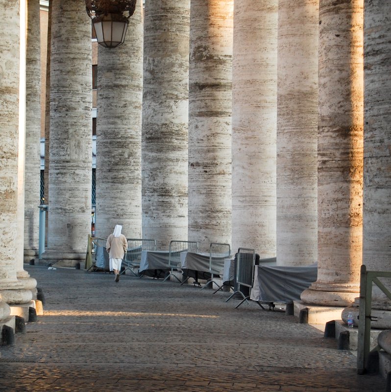 A nun walks around the columns in St Peter's Square, Rome
