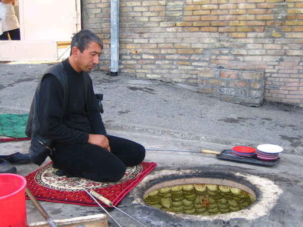 Tashkent - Man cooking samsa (meat pies) in traditional oven