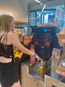 Camille making orange juice at the grocery store