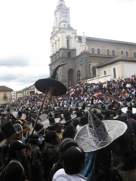 Men dancing and crowds watching during festival in Cotacachi