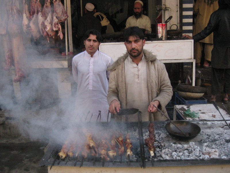 Afghani man cooking kebabs. 