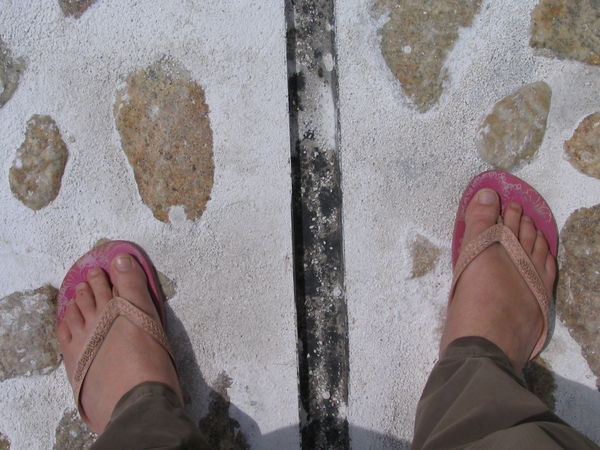 Left foot north of the equator, and right one south