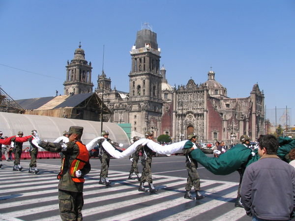 The huge Mexican flag is taken down and carried into the Palacio Nacional
