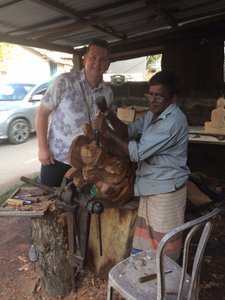 Wood carver outside his shop