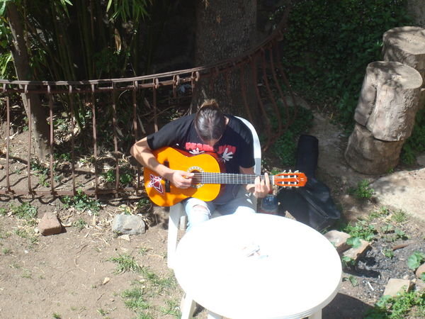 Reto playing guitar in the courtyard