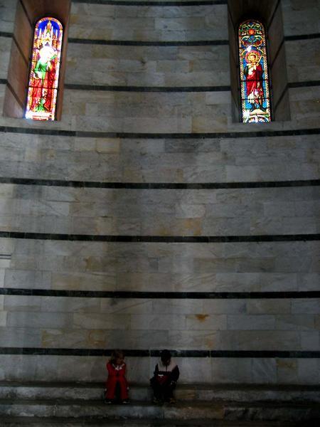 two children below stained glass windows inside the baptistry....