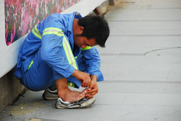 yes, that's right...you aren't seeing things...he IS cutting his toe nails on the street!