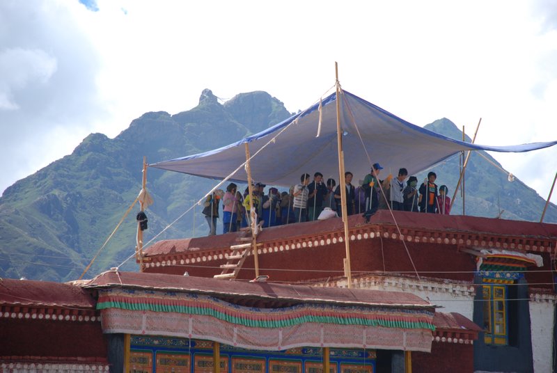 People fixing the jokhang temple whilst praying/singing