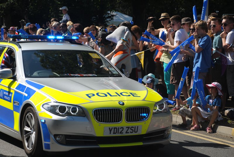 Police car waves the Olympic mascot