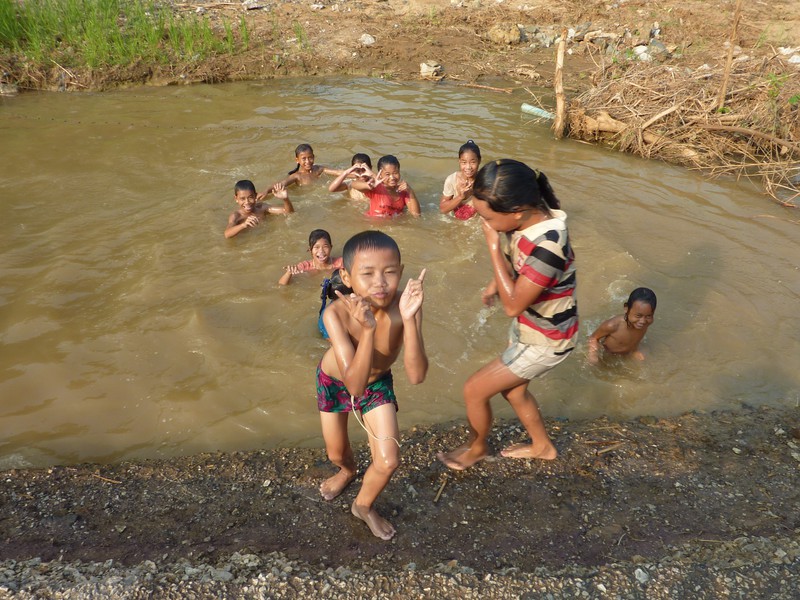 Children enjoying swimming in a small pond