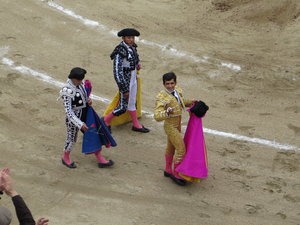Matador being thrown hats and roses in the ring after the bull fight