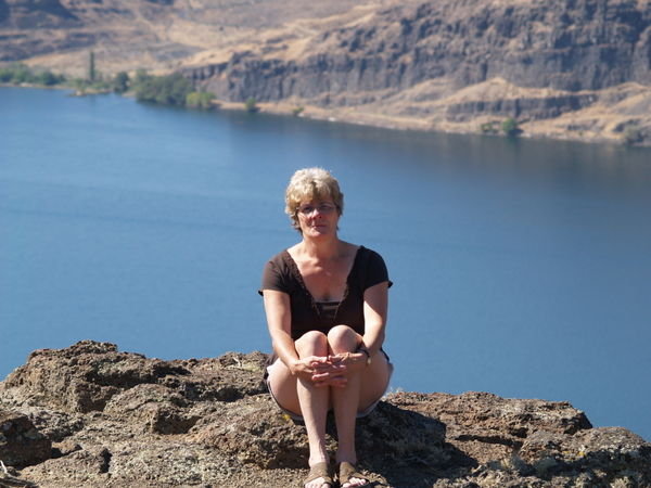Carolyn sitting on ledges over Columbia River