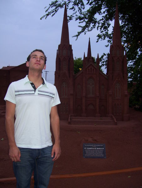 Andrew looking pious in front of a sand sculpture of a church in Charlottetown