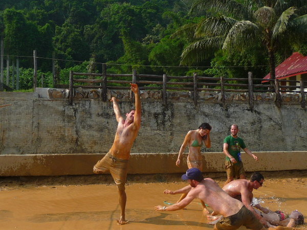 Drunk tourists playing mud volleyball