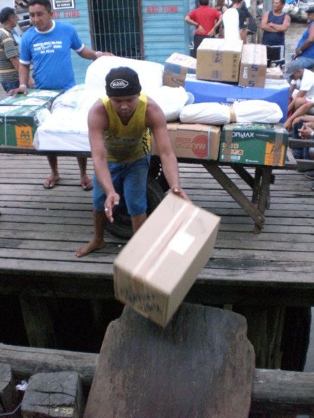 Metiendo las mercancias en el barco para las comunidades que viven en el Amazonas