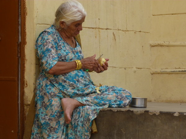 Mujer india pelando patatas