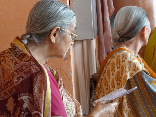 Mujeres leyendo sus rezos durante la ceremonia de Risikesh de por la tarde